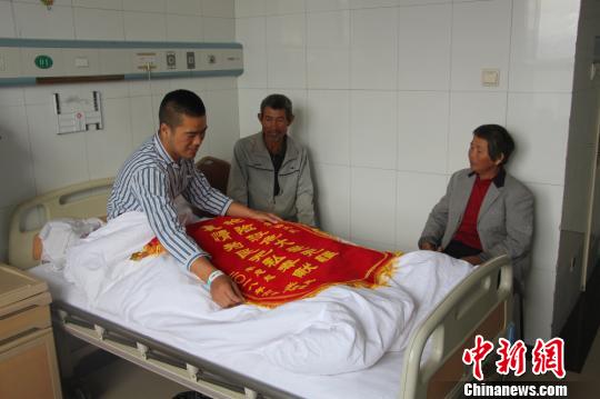 被救的李忠起、張總鳳夫婦看望受傷后的李運(yùn)飛?！⊥粲?攝