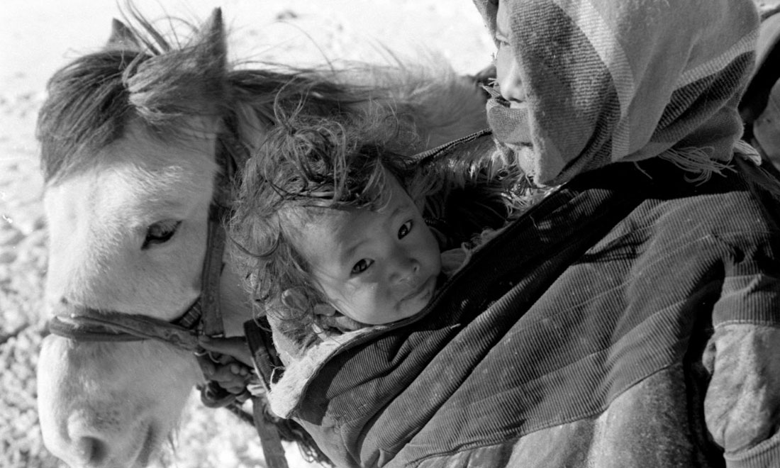 1990年3月，西藏當(dāng)雄縣納木湖鄉(xiāng)三村女牧民斯卓不畏嚴(yán)寒，懷抱幼子，準(zhǔn)備到遠(yuǎn)處放牧。新華社記者覺(jué)果攝