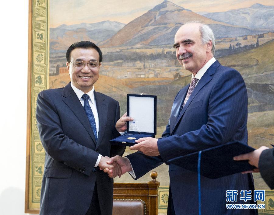 6月19日，國務院總理李克強在希臘議會大廈會見希臘議長米馬拉基斯。這是會見前，米馬拉基斯代表希臘議會向李克強授予議會金質勛章。新華社記者 王曄 攝