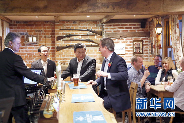 這是會晤結束后，習近平在卡梅倫陪同下乘車前往當?shù)匦℃?zhèn)體驗酒吧文化。新華社記者 鞠鵬 攝